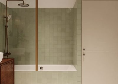 Drewniana szafka łazienkowa z umywalką nablatową i złotymi kinkietami na tle zielonych płytek.